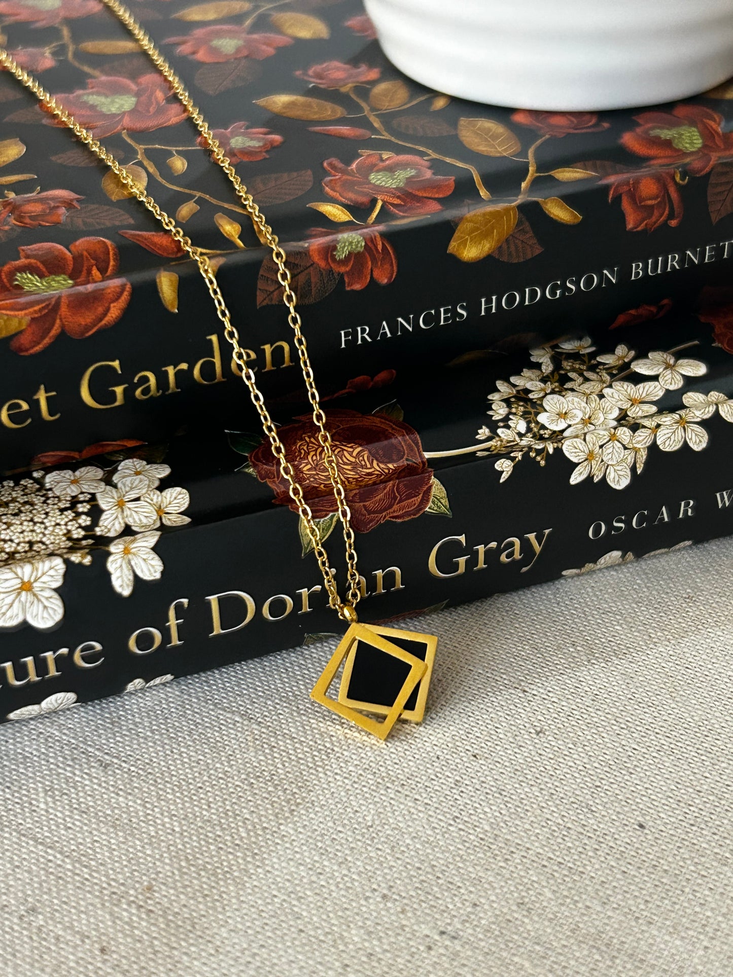 Gold necklace on a book with floral design
