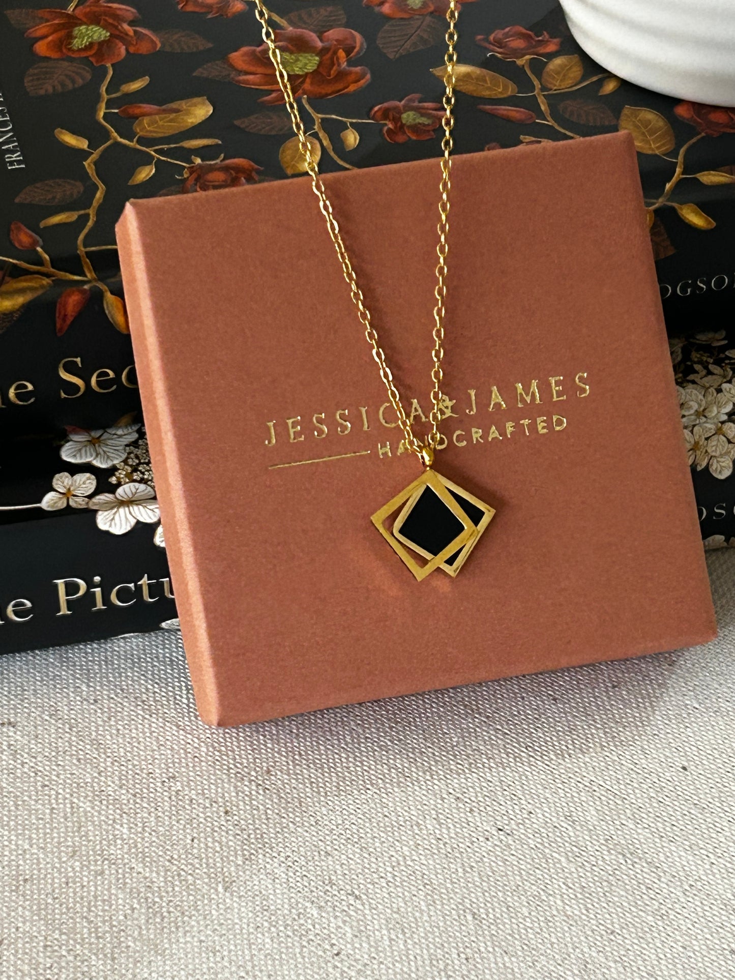 Jewelry set with 'Jessica James' branding on a brown box.