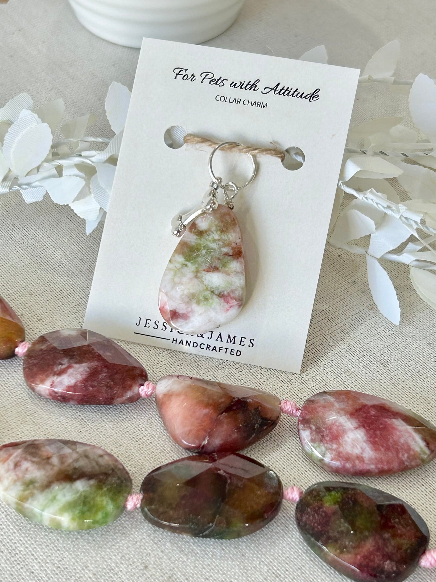 A multi-colored Agate crystal pet collar charm Jessica & James , attached to a silver-toned bone with a double split ring.