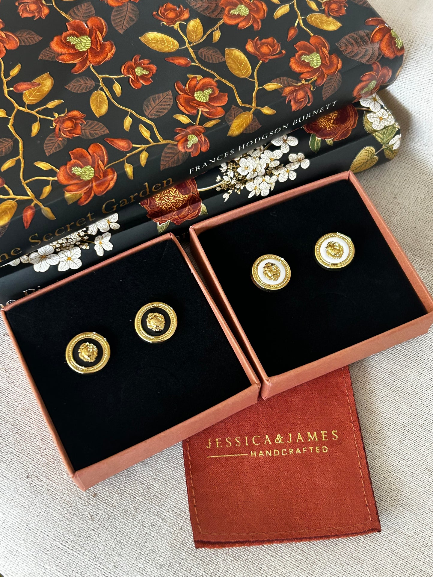 Gold earrings in a Jessica James box with a floral notebook.