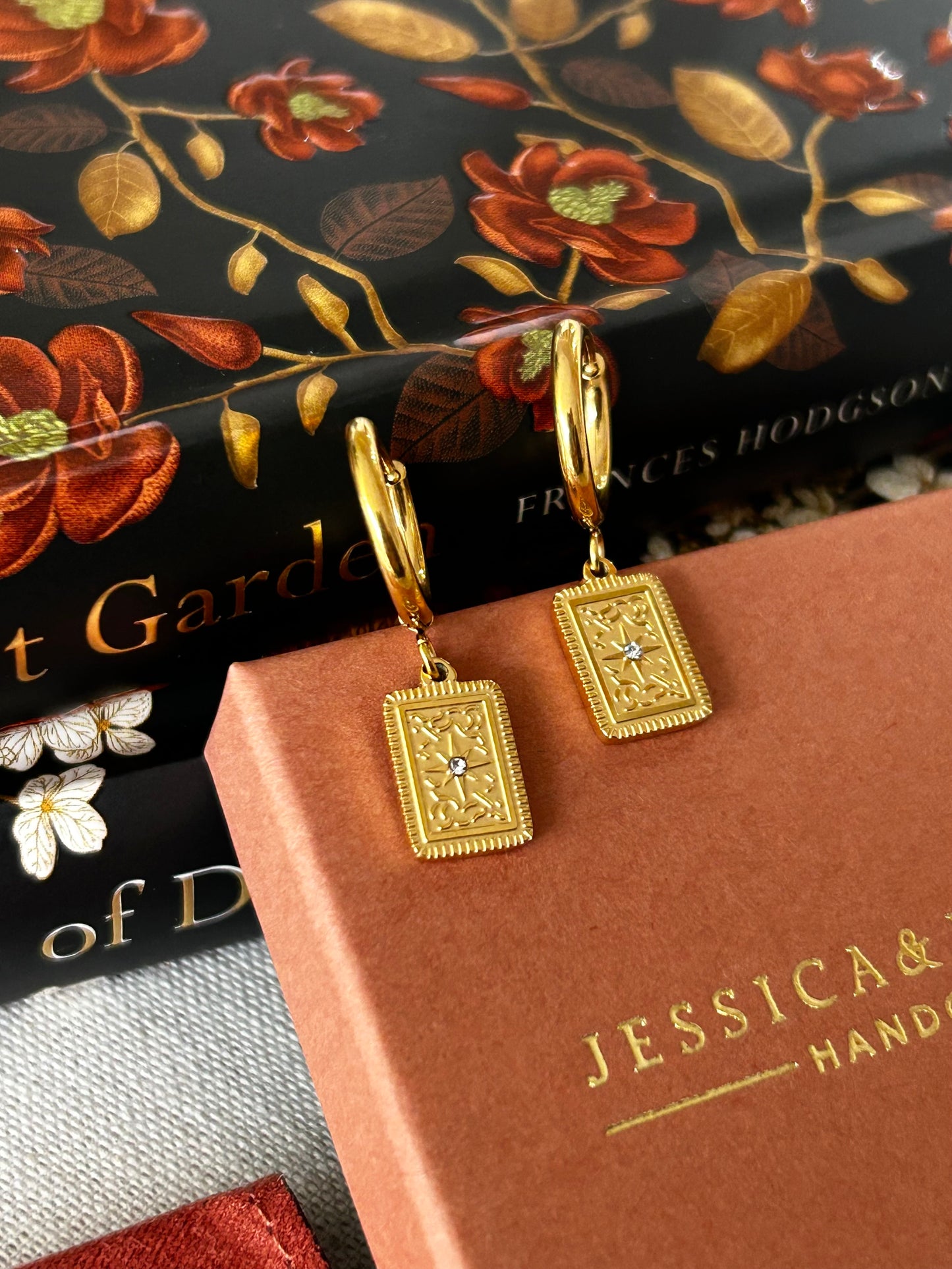 Gold book-shaped earrings . Star huggie hoops in gold