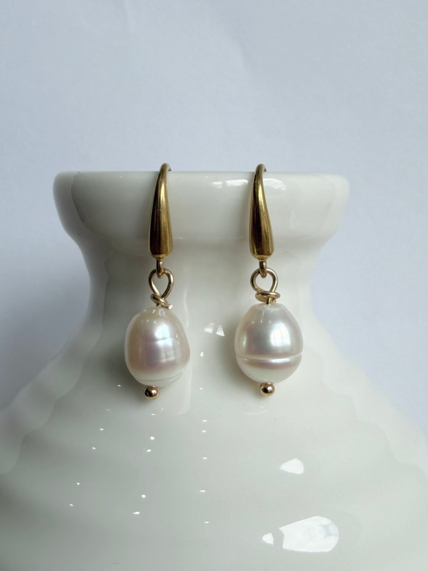 Gold bridal Pearl earrings with gold hooks on a white stand Jessica & James Stylelab 