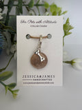 A pet collar charm card from Jessica & James Handcrafted, featuring a round large stonestone crystal charm with a silver bone-shaped charm
