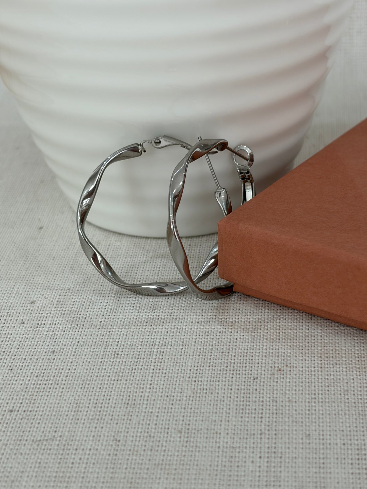 A pair of silver-toned twisted hoop earrings  handmade from Jessica and James stylelab