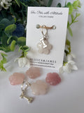 A pet collar charm displayed on a white card labeled 'For Pets with Attitude' and 'COLLAR CHARM,' with the brand name 'JESSICA&JAMES' visible. The charm is a pale pink translucent flower-shaped piece with a silver bone-shaped clasp.