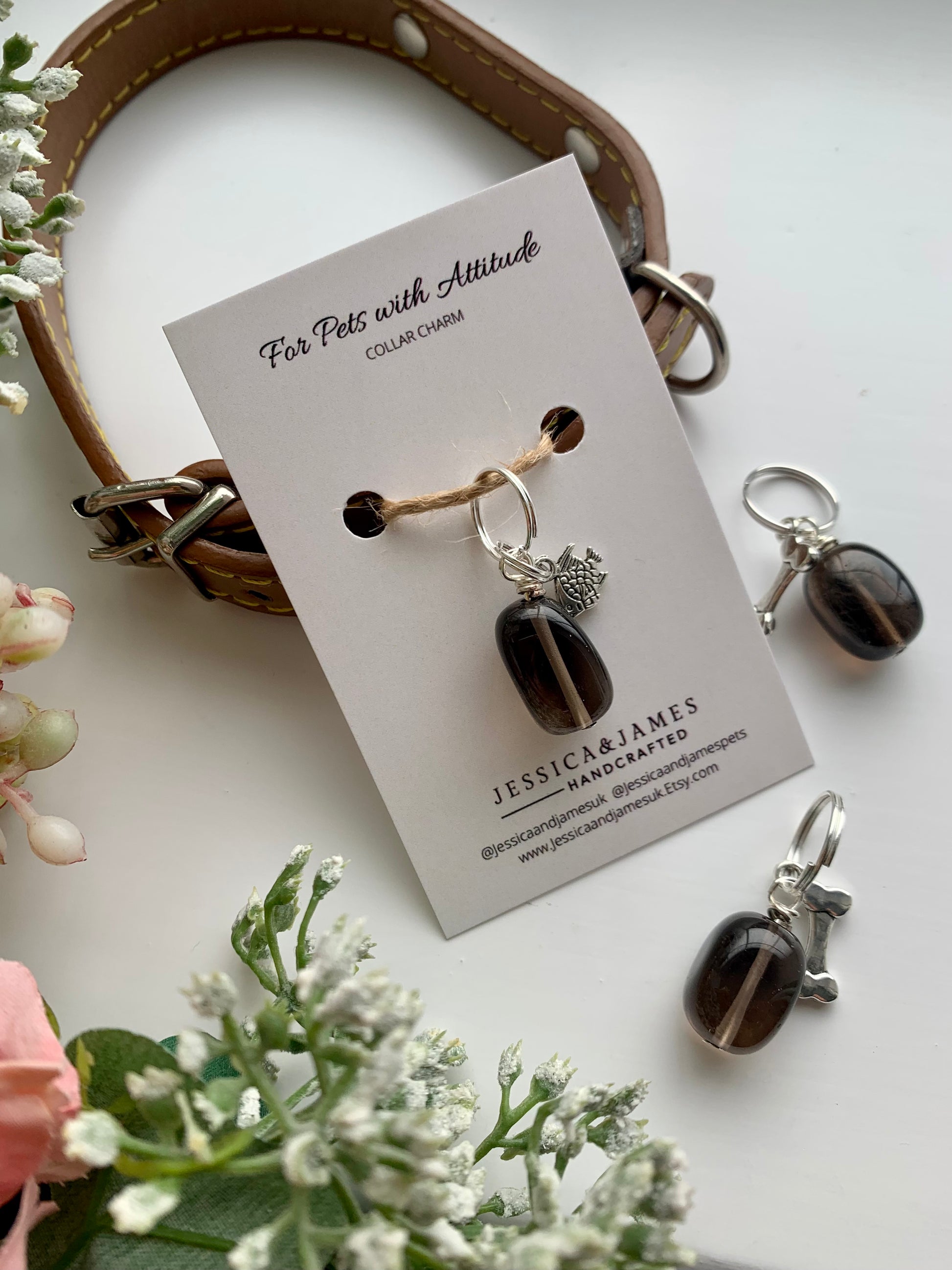 A Smokey Quartz gemstone collar charm for dogs displayed on a card, alongside a split ring for dogs a bone-shaped charm.