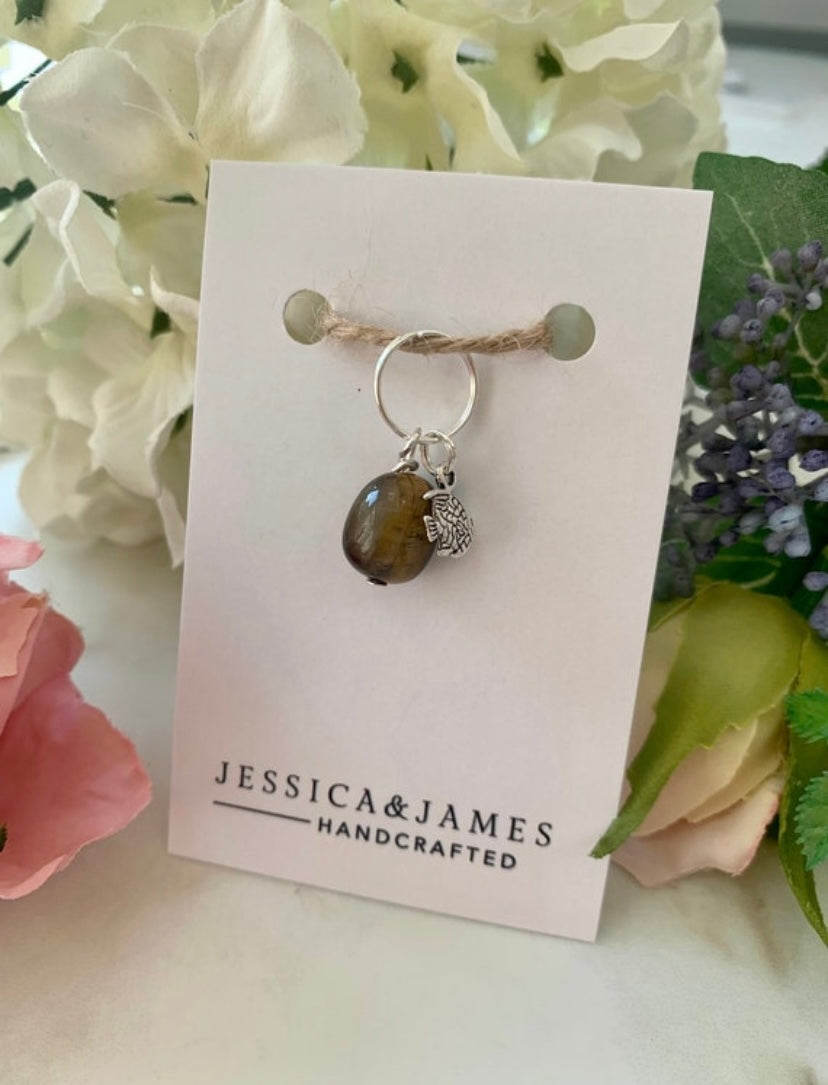 A tiger's eye gemstone pet tag with a double split ring, displayed on a card with 'Jessica & James Handcrafted' branding.